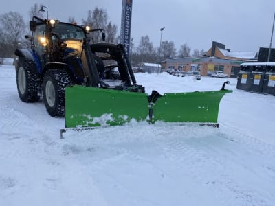 En traktor som plogar bort snö.