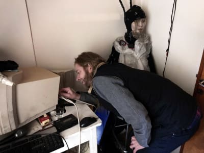 Keuhkojen Kake Puhuu sovittelemassa johtoja tietokoneen takana.