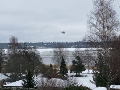 En helikopter ovanför Pojoviken i Österby en grå dag i januari.