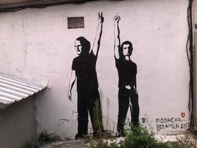 Väggmålning i svart och vit som föreställer två belarusiska DJ-artister som visar segertecknet och en knuten näve.