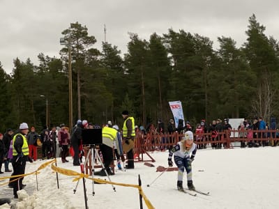 En skidare åker i väg på en skidtävling för juniorer.
