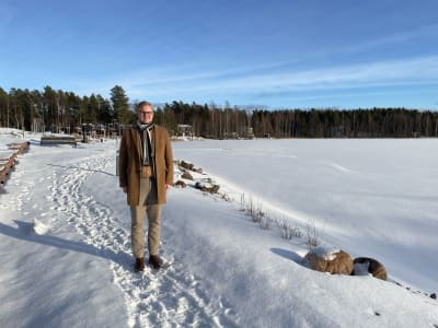 Mies seisoo lumisessa maisemassa.