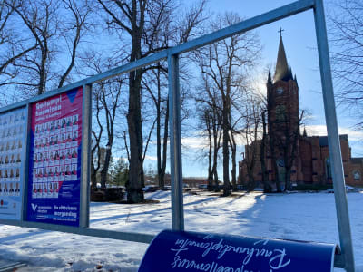 Valaffischer på rad. Lovisa kyrka syns genom en av de tomma ramarna.