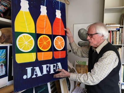 Grafikern Erik Bruun förevisar sin Jaffa-affisch i sin hemateljé på Sveaborg.