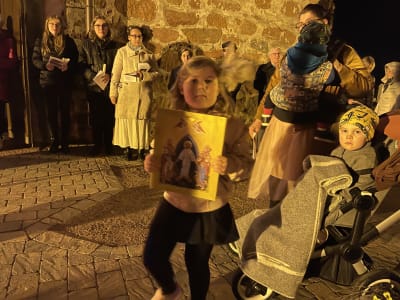 vuxna och barn i procession nattetid