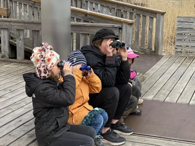 Barn och en kvinna som tittar med kikare.