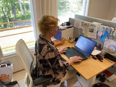 Kvinna sitter vid en dator och jobbar.
