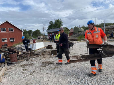 Folk som bär metallskrot.