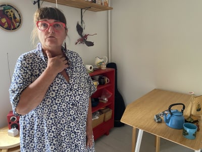 Äldre kvinna i röda glasögon.