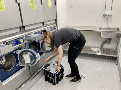 Studerande tar ut byke ur tvättmaskin i bykstugan i studentbostad.