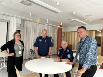 En civil kvinna, två poliser och en civil man ser mot kameran. 