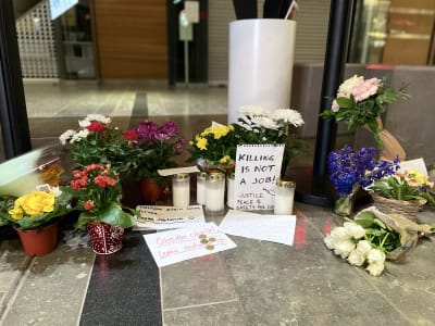 Blommor, ljus och kort vid en minnesplats