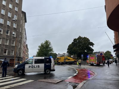 En polisbil dirigerar trafik, medan en brandbil i bakgrunden förbereder reparation av en spårvagnsledning på Gräsviksgatan. 