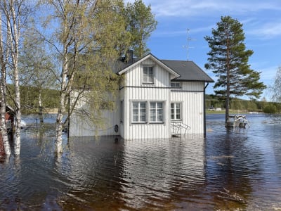 Ett hus vars stenfot är dränkt i vatten.