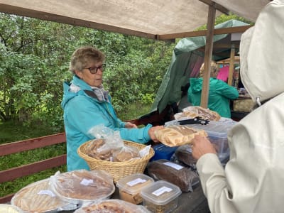 En kvinna som säljer bröd på en marknad.