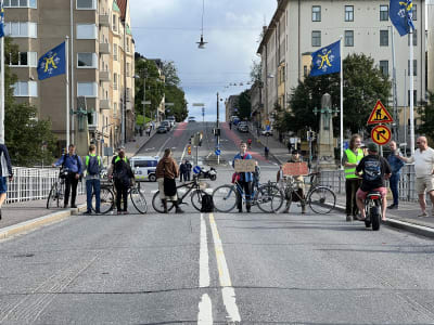 Bild av personer som blockerar körfältet på Aurabron i Åbo. 