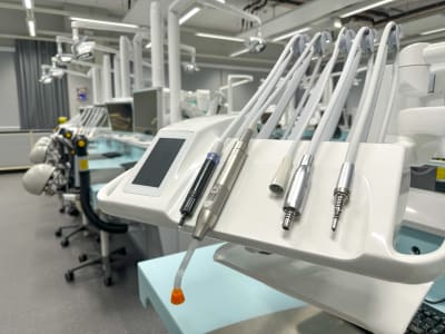 Ett utbildningsrum för blivande tandläkare med instrument för undersökning av tänderna i förgrunden.