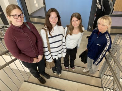 Gymnasietjejer på rad i en trappa.