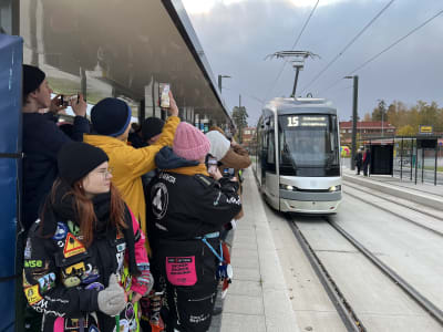 Huvustadsregionens första snabbspårvagn, linje 15 precis före sin första tur. Hållplatsen är packad med människor som vill åka med den första turen.