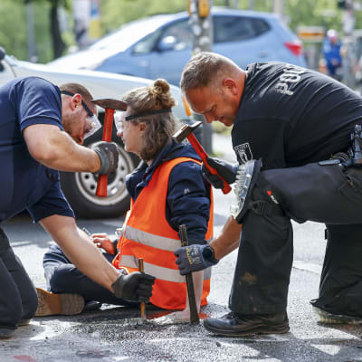 Polisen använder verktyg för att försöka få loss en Letzte Generation-aktivist som limmat fast sin hand på en bilvägi Berlin.