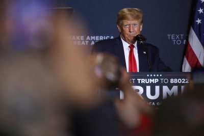 Donald Trump vid talarpodiet under ett kampanjevenemang. Han ser fundersam ut.