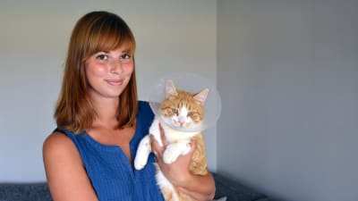 Maria Frände med katten Sputnik som blev överkörd av en robotgräsklippare.