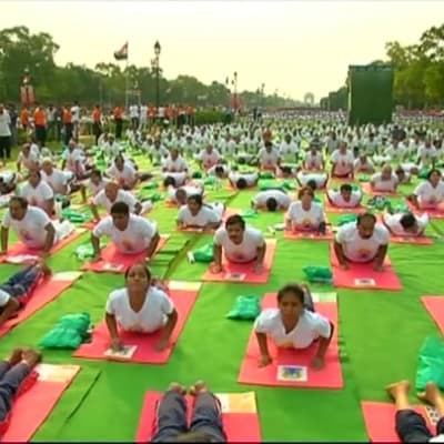 Tiotusentals människor yogar i Delhi