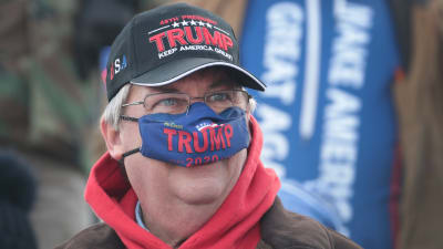 Manlig Trump-anhängare med coronaskydd över näsan.