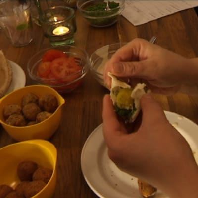 Falafelin syömistä ruokapöydässä.