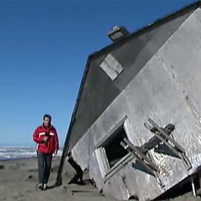 Toimittaja Mika Mäkeläinen sortuneen talon edustalla Alaskassa
