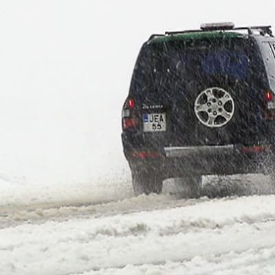 Auto lumisella tiellä Inarissa kesäkuussa.