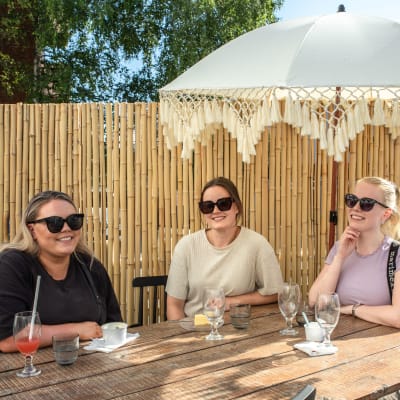 Sofia Manninen,  Liisa Matikainen ja Mari Turunen istuvat Rovaniemeläisen ravintola Cafe & Bar 21 terassilla. 