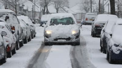 Bil som är täckt av snö i London. 