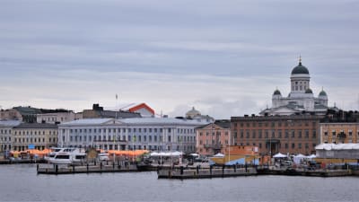 Helsingfors fotograferat från vattnet. På bilden syns Salutorget med de orangea försäljningstälten, svenska ambassaden, stadshuset i Helsingfors, och i bakgrunden Helsingfors domkyrka.