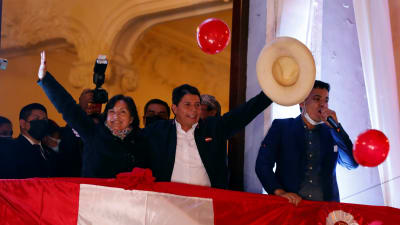 Pedro Castillo ja Dina Boluarte vilkuttavat parvekkeelta tukijoilleen Perussa 19. heinäkuuta 2021.  