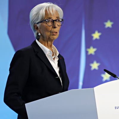 Europeiska centralbanken ECB:s ordförande Christine Lagarde står vid ett talarpodum med EU-flaggan i bakgrunden.