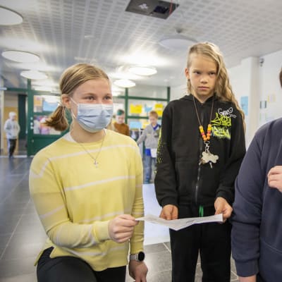Pataluodon koulun 4.-luokkalainen Väinö Lahtinen näyttää hyvien tekojen passiaan 9.-luokkalaisille Erin Parkkiselle ja Mikko Nuutiselle.