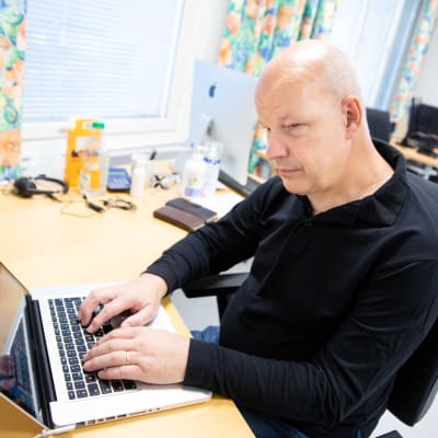 Hannu Suvanto käyttää kannettavaa tietokonetta Varsinais-Suomen näkövammaiset ry:n kerhotilassa Turussa.