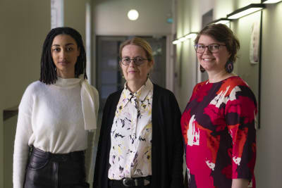 Tre kvinnor står i korridor, forskare vid universitet. 