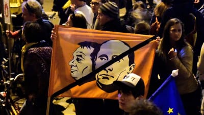Demonstranter bär på en flagga med en bild på premiärminister Viktor Orbán och Rysslands president Vladimir Putin.