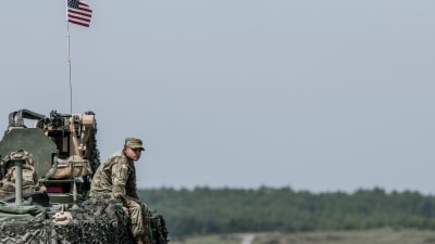 En amerikansk soldat sitter på ett pansarfordon