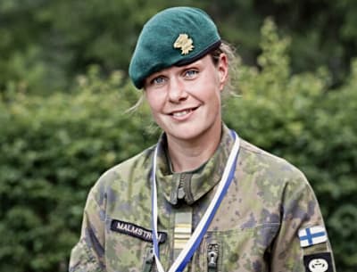 Henrika Backlund småler mot kameran iklädd militärtjänstgöringsuniform.