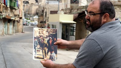 Yehuda Shaul visar en bild över hur livet var förut här på gatorna.