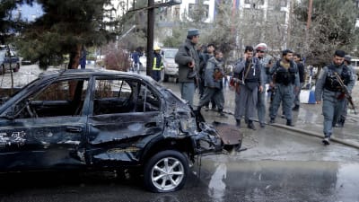 Säkerhetsstyrkor granskar en bil efter en själmordsbombares attack i Kabul.
