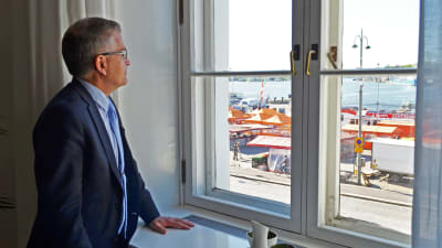 Stadsdirektör Jussi Pajunen tittar ut genom sitt fönster, som vetter mot Salutorget.