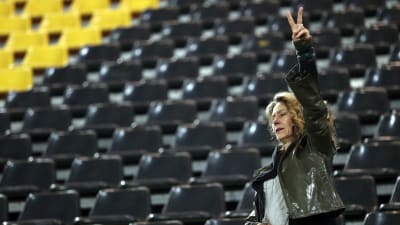 En kvinna gör fredstecknet på Dortmunds stadion.