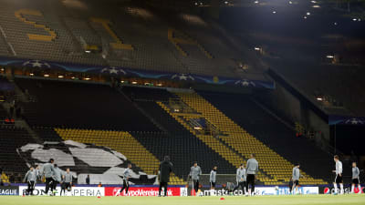 En öde stadion och spelare som värmer upp.
