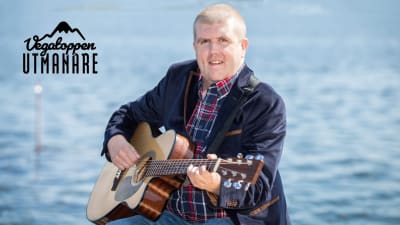 Tom Håkans spelar gitarr vid havet.
