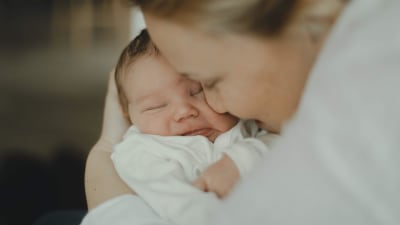 En närbild där Carro håller om sin nyfödde son Björn.