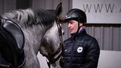 Jerry Kvarnström står bredvid en häst.